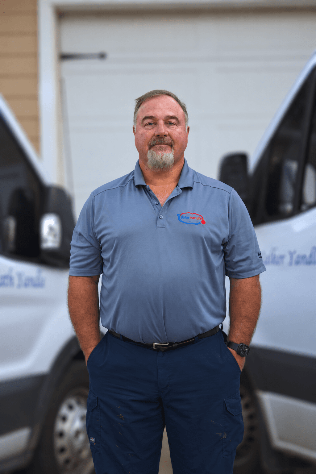 Portrait of Ed Lever, owner of Lever Repairs, standing in front of the service vans